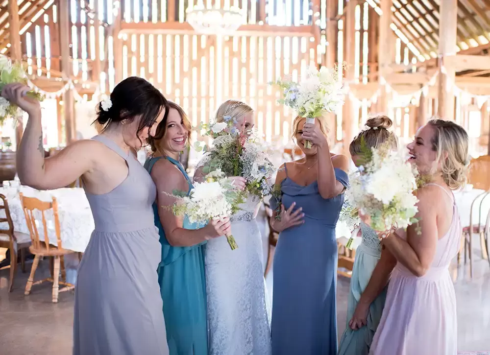 Tin Roof Weddings Barn Weddings Venues Near Me from Photographer Robert Knapp Bride and bridesmaid are all smiling, waving their flowers around