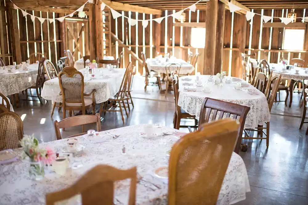 Tin Roof Weddings Barn Weddings Venues Near Me from Photographer Robert Knapp An overview of the reception area all the tables are set. All the tables and chairs are mismatch from tables and farm chairs. The setting is beautiful.